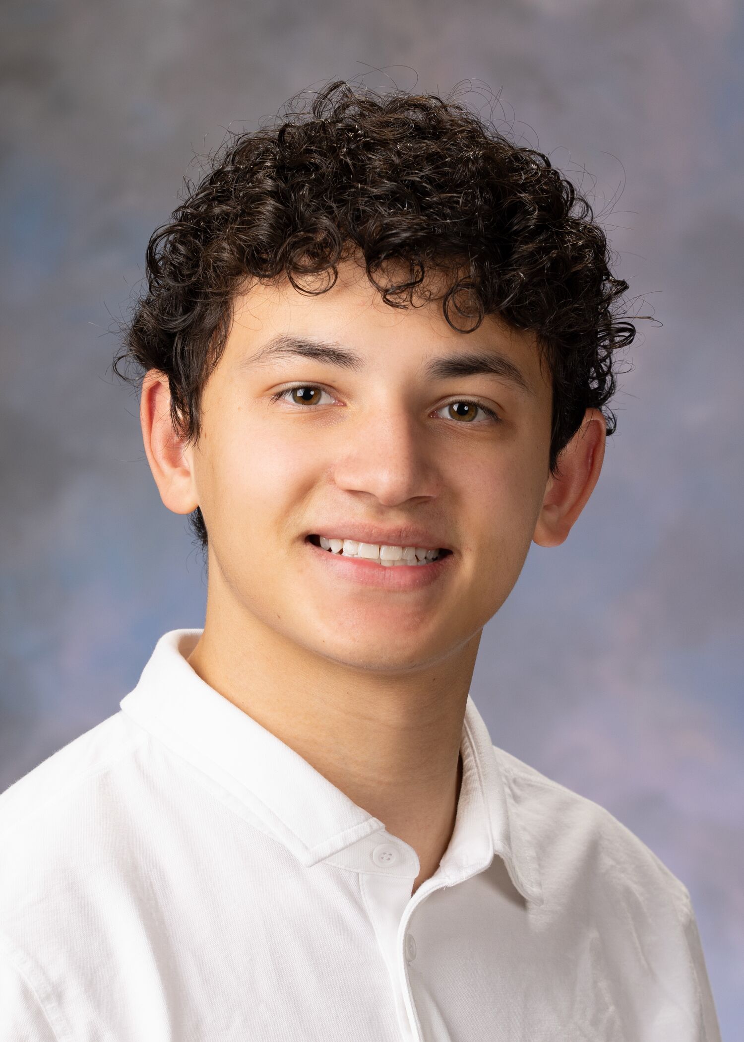 Portrait of David Henson. Davis has short curly hair and is wearing a white polo shirt.