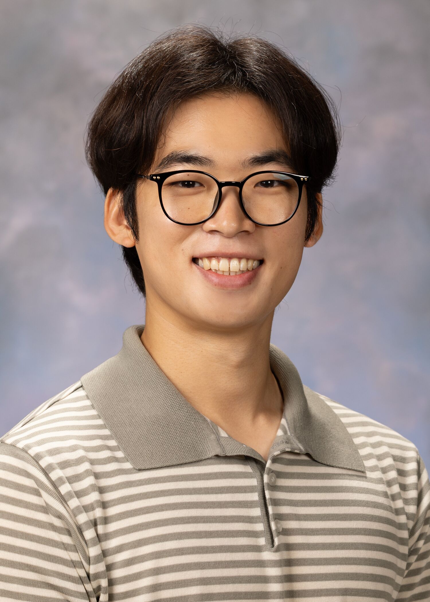 Portrait of Seungbeom Oh. He has short brown hair, dark round rimmed glasses, a stripped collared shirt. The background is a mix of grays and pinks. 