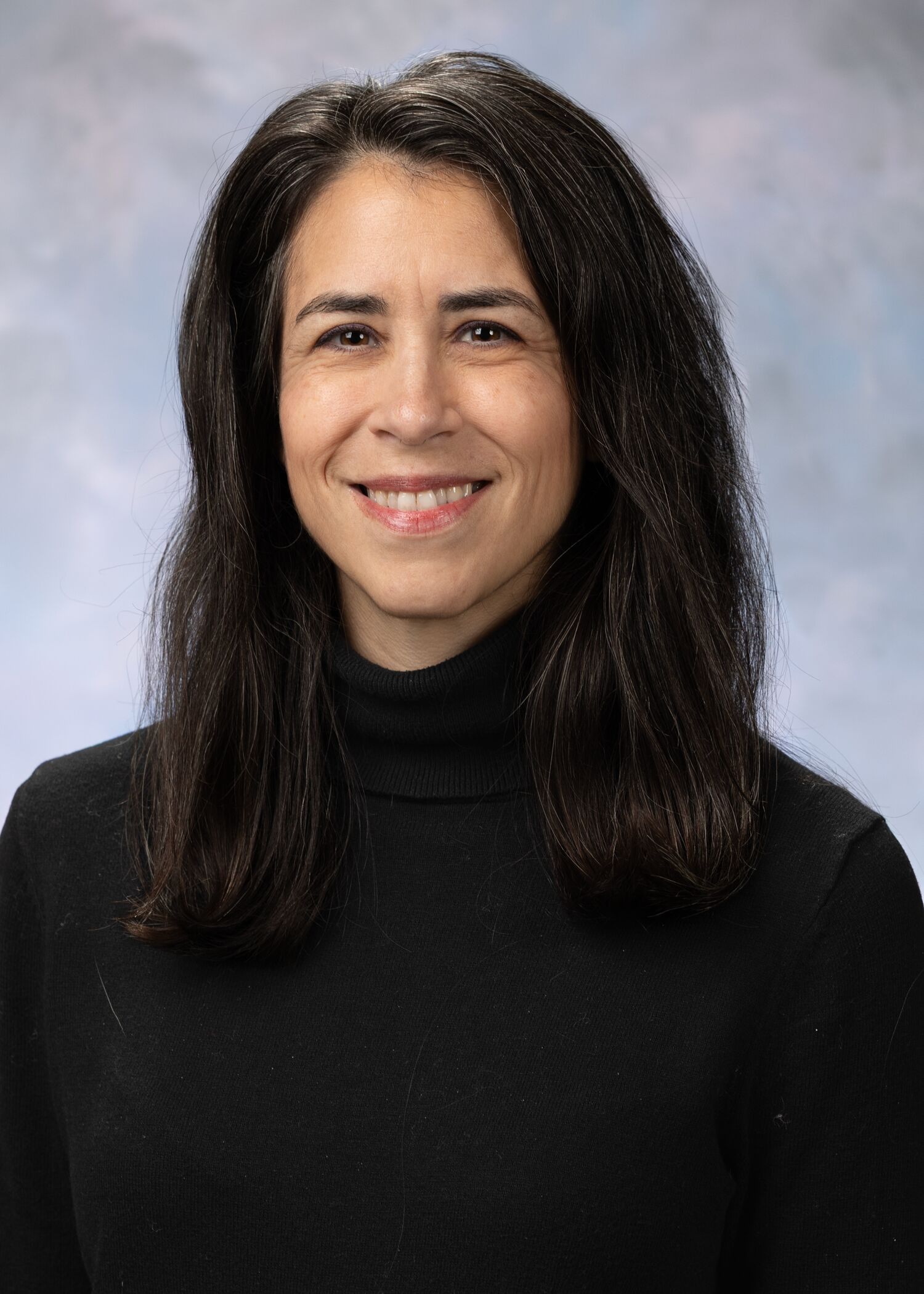 Portrait of Megan Rosenfield. Megan has dark shoulder length hair and is wearing a black turtleneck sweater.