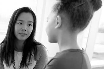Health care provider intently listening to female child