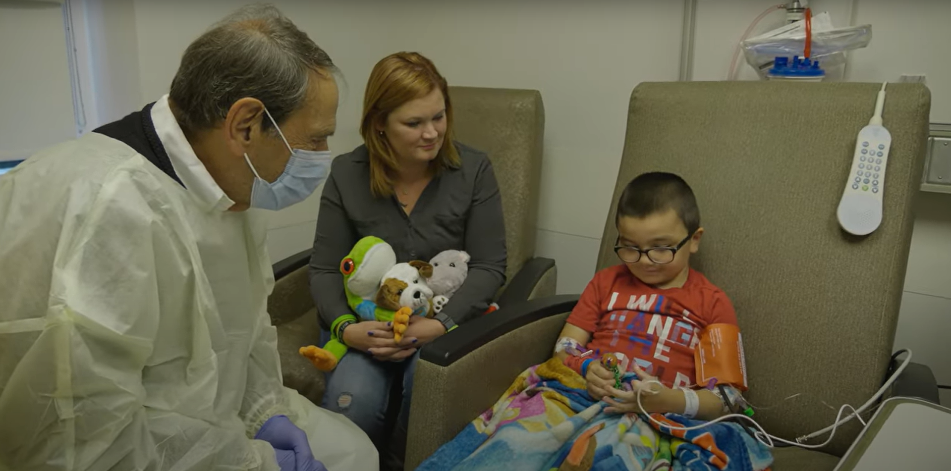 Doctor and mother sitting and looking at child in chair