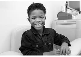 Smiling elementary aged boy waiting in a lab