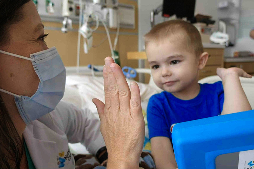 Josiah gives a high five to a clinical team member