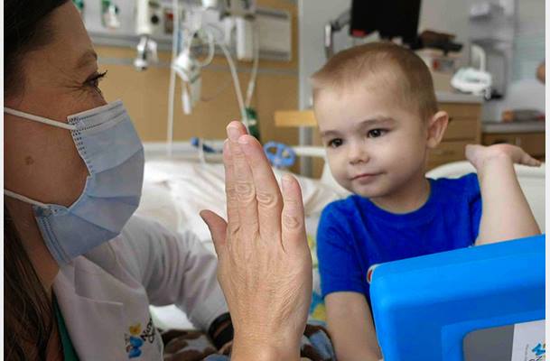 Josiah gives a high five to a clinical team member