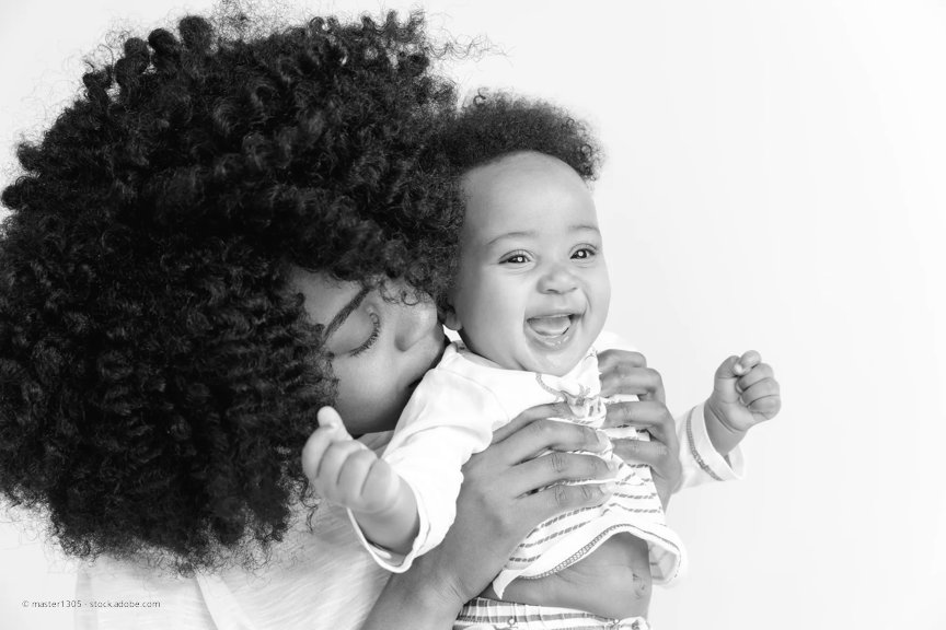 Closeup portrait of woman holding onto her little smiling infant daughter on white background. 